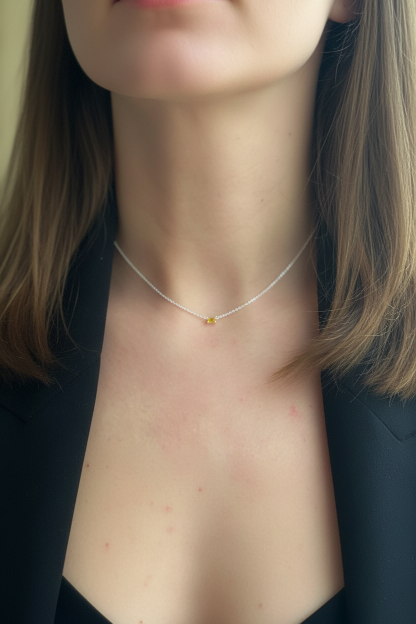 Woman wearing silver necklace with yellow stone